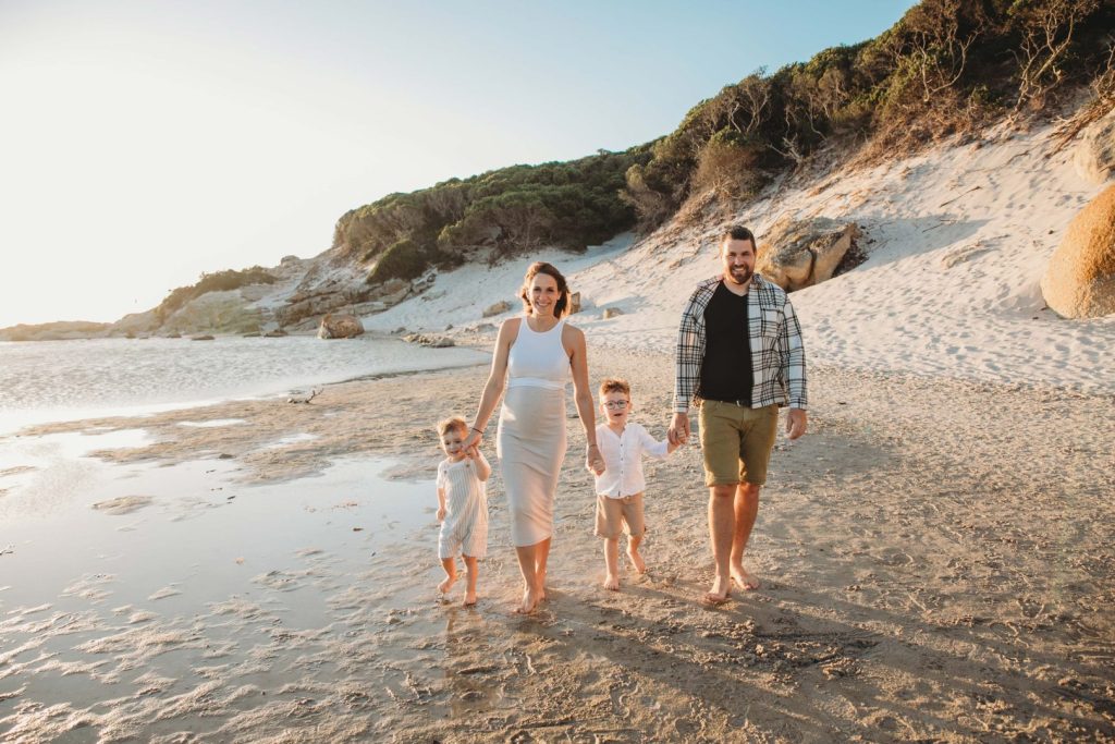 Family walking barefoot on Noordhoek Beach in Cape Town during golden hour family photo shoot