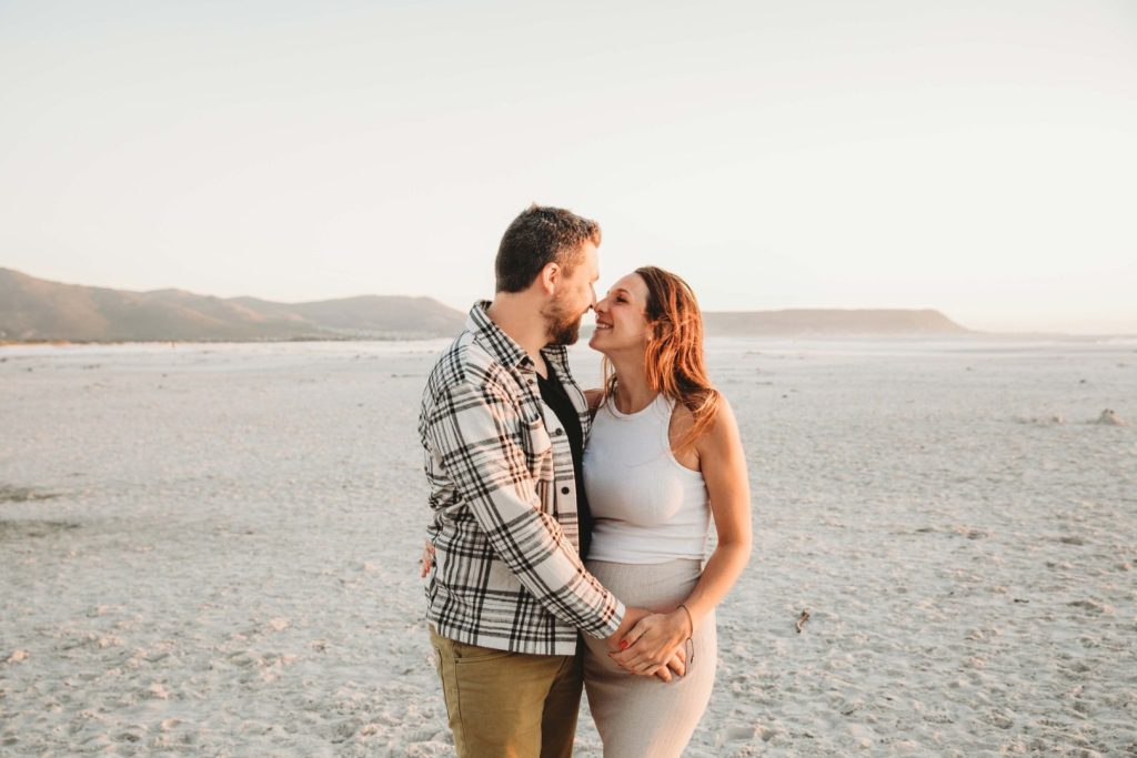 Pregnant mother on windy Noordhoek Beach, Cape Town