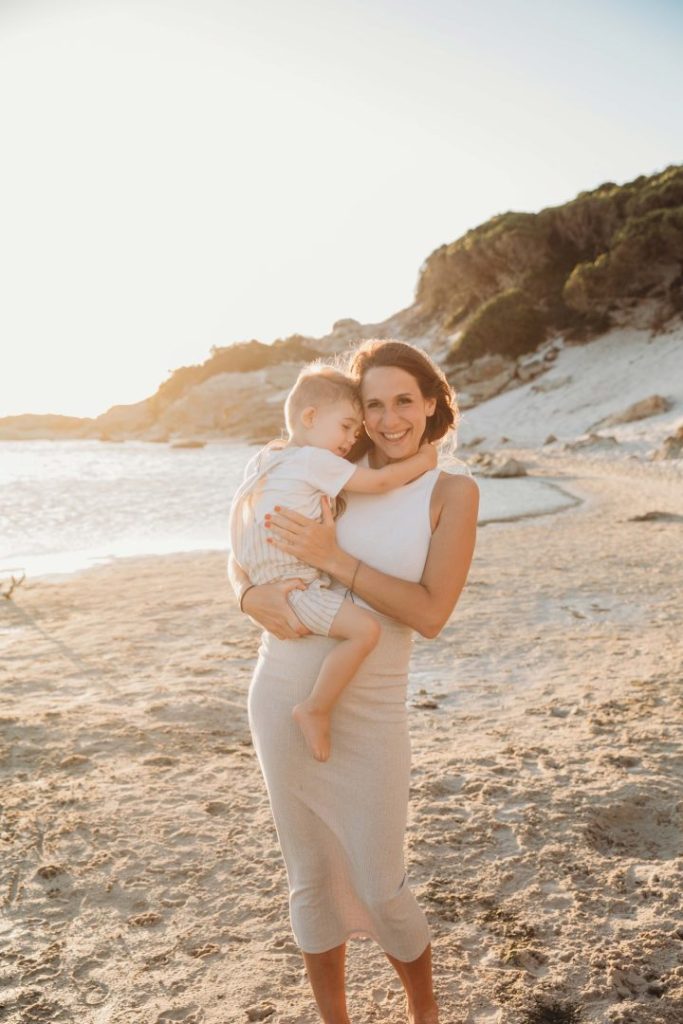mom and son embracing on beach during golden hour 