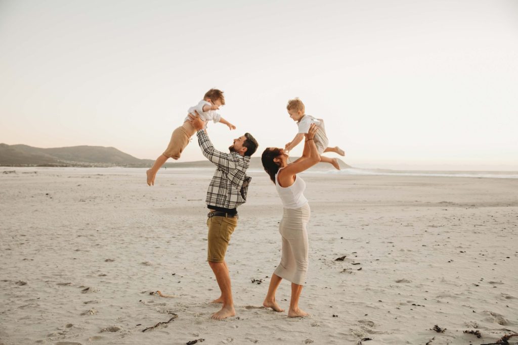Family walking barefoot on Noordhoek Beach in Cape Town during golden hour family photo shoot