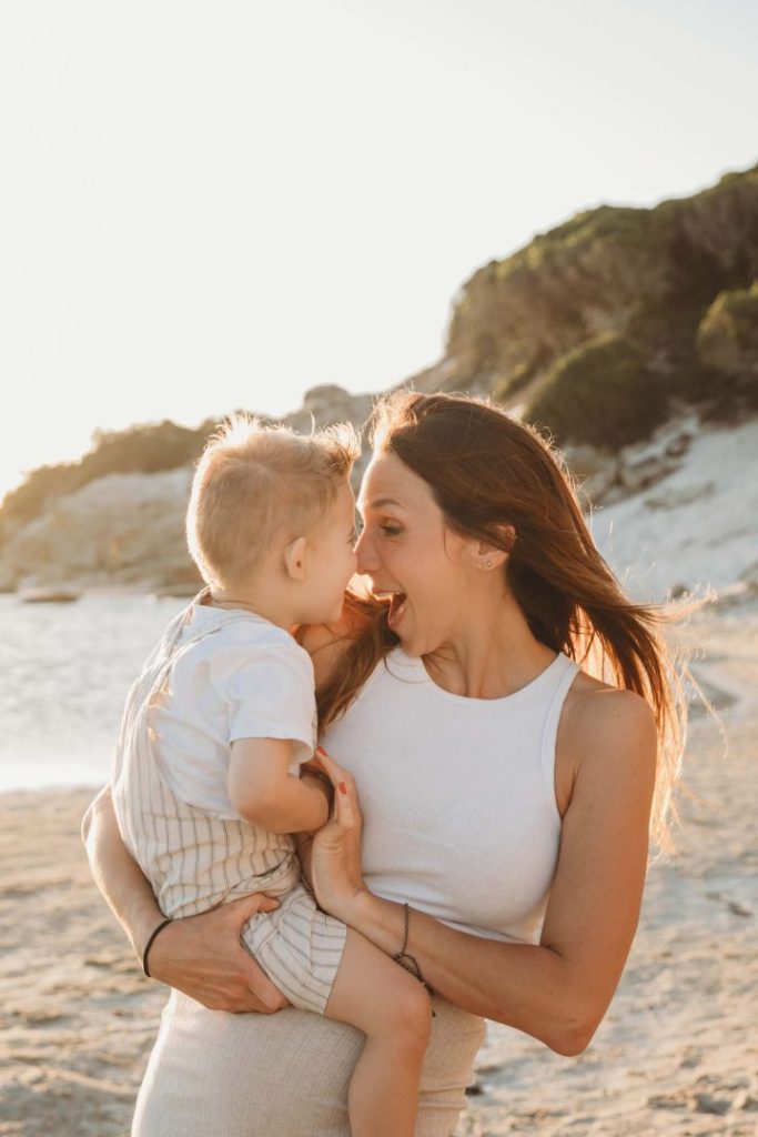mom and son embracing on beach during golden hour 