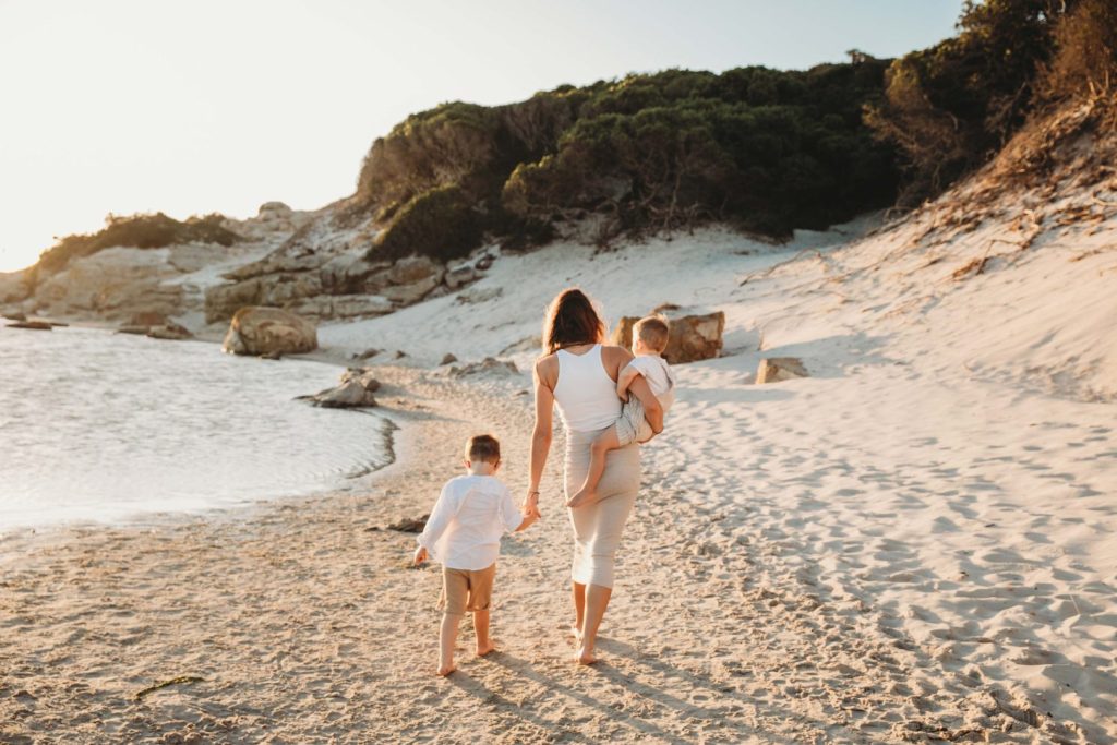 Family walking barefoot on Noordhoek Beach in Cape Town during golden hour family photo shoot