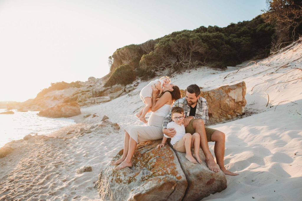 family giggling and laughing together during golden hour 