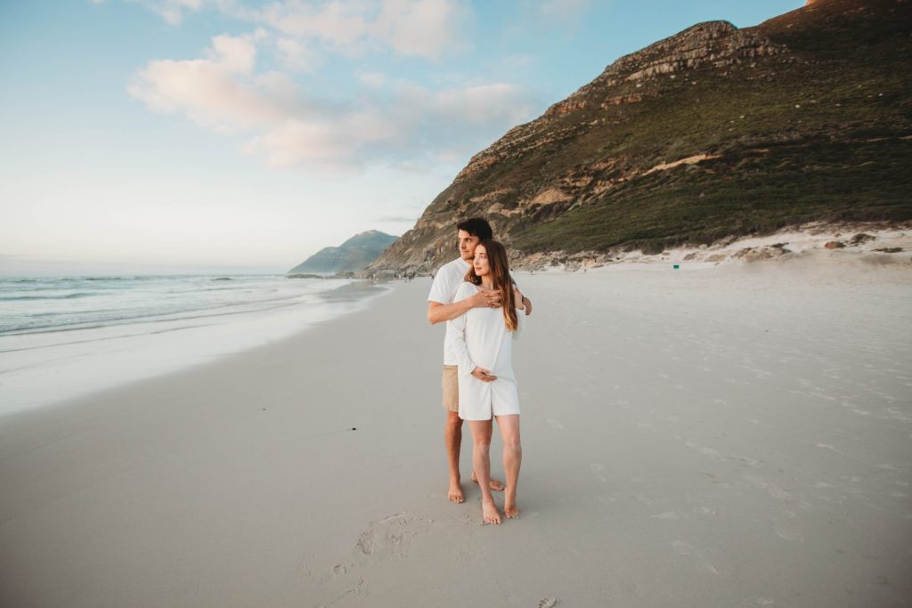 Couple embracing during maternity shoot on Cape Town beach