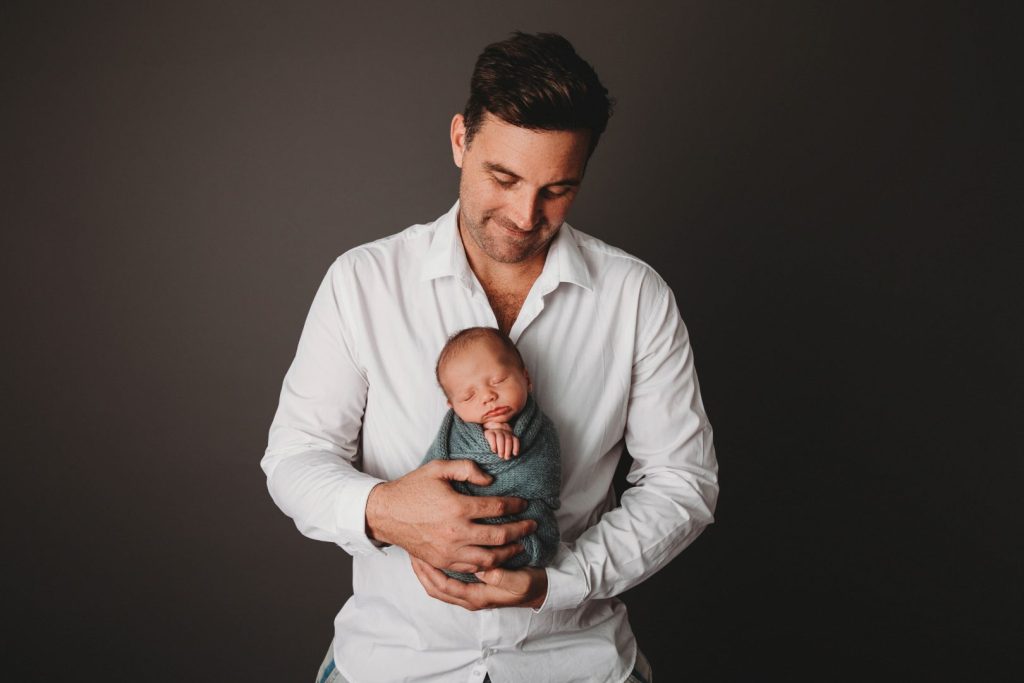 Studio portrait of a newborn baby held by parents, posed family image taken in Cape Town