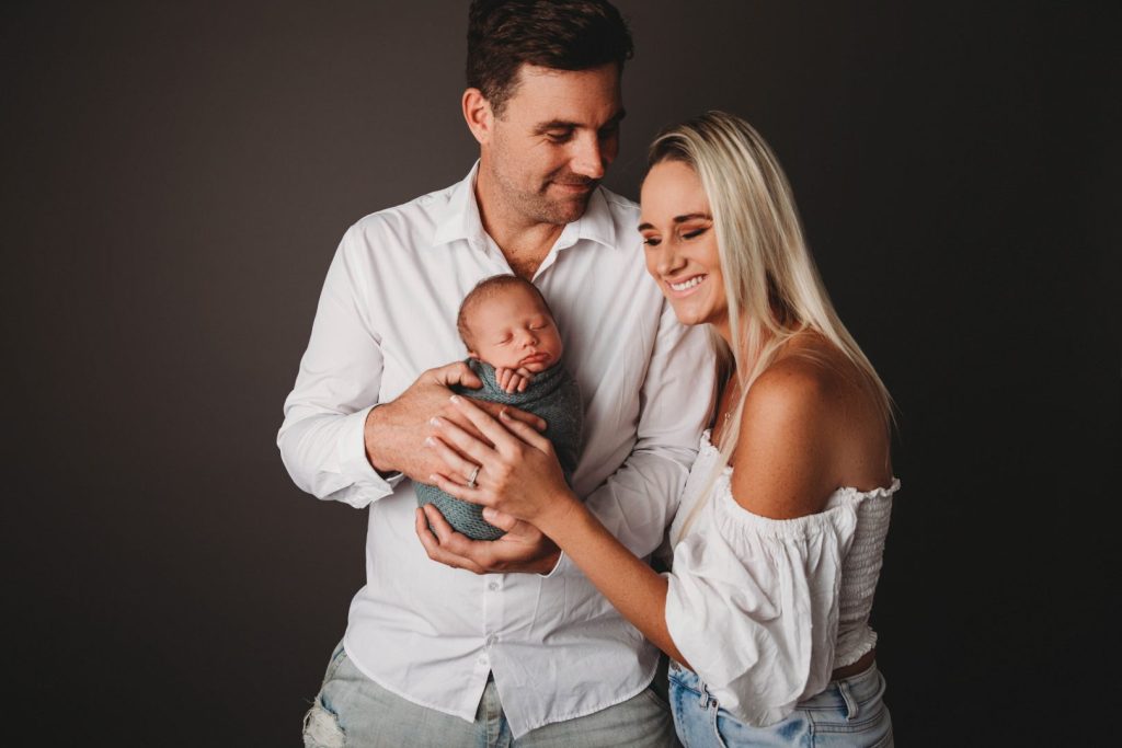 Studio portrait of a newborn baby held by parents, posed family image taken in Cape Town
