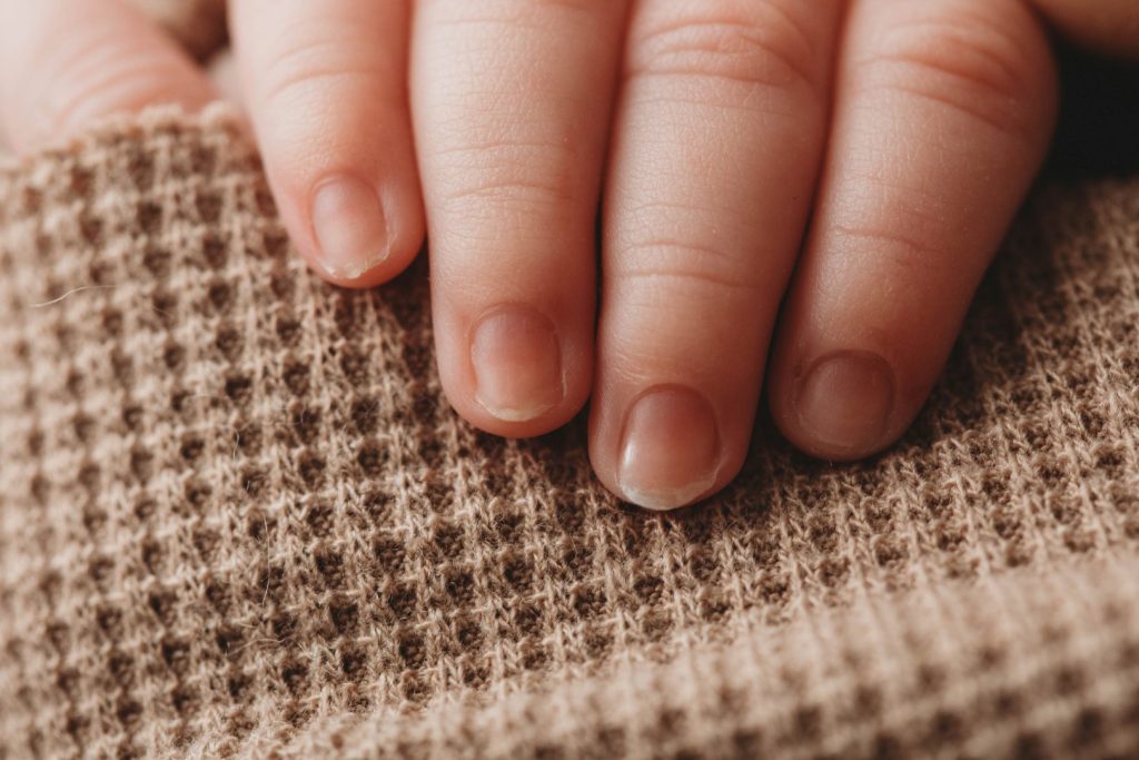 Close-up photo of a newborn baby’s hands in a posed studio setup, Cape Town photographer