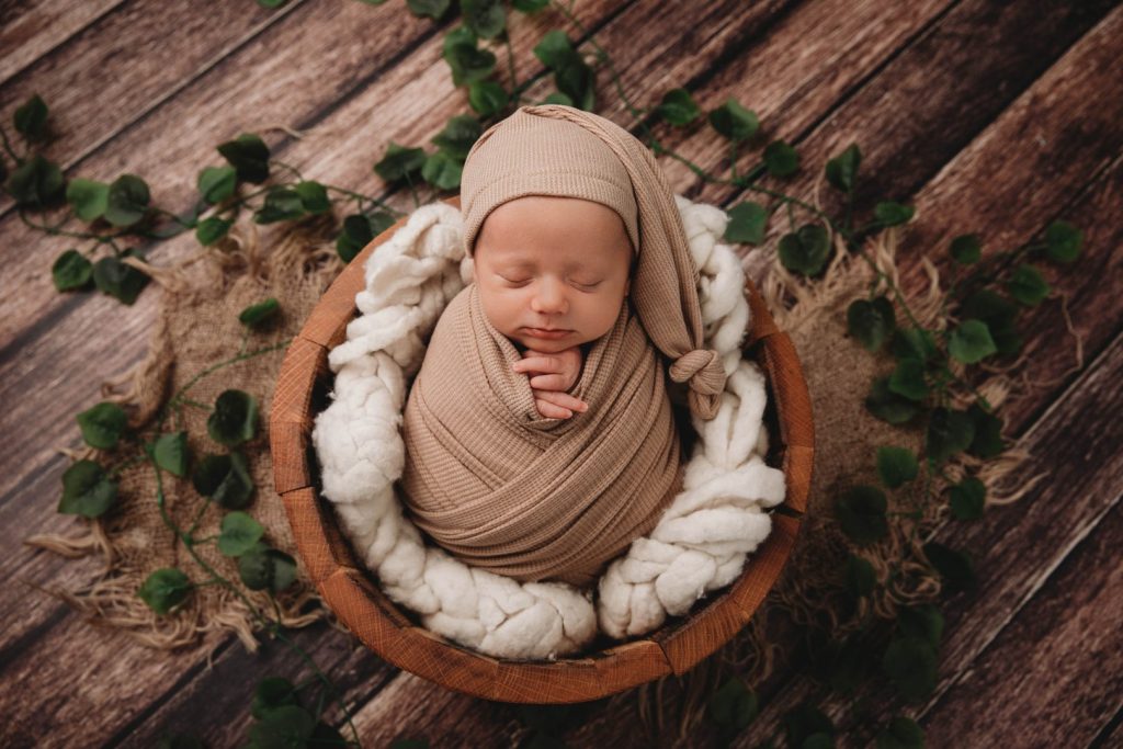 Posed newborn baby wrapped in a soft neutral blanket, studio photography in Cape Town