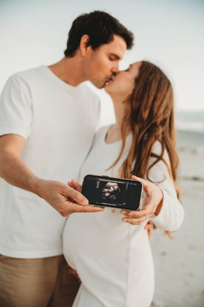 Candid maternity moment with couple embracing on Noordhoek Beach, Cape Town