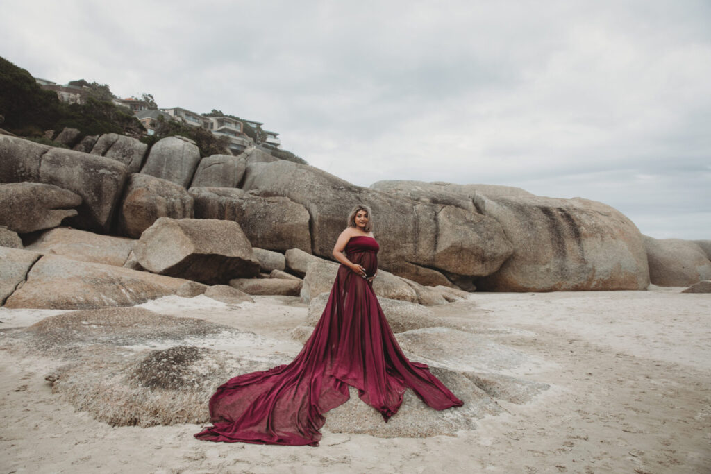 Maternity photography session in Cape Town with a pregnant mom wearing a purple dress on Llandudno Beach