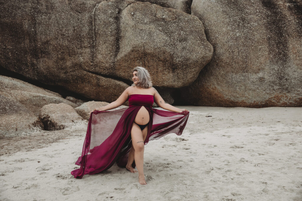 Llandudno Beach maternity photoshoot in Cape Town featuring an expectant mother in a purple dress