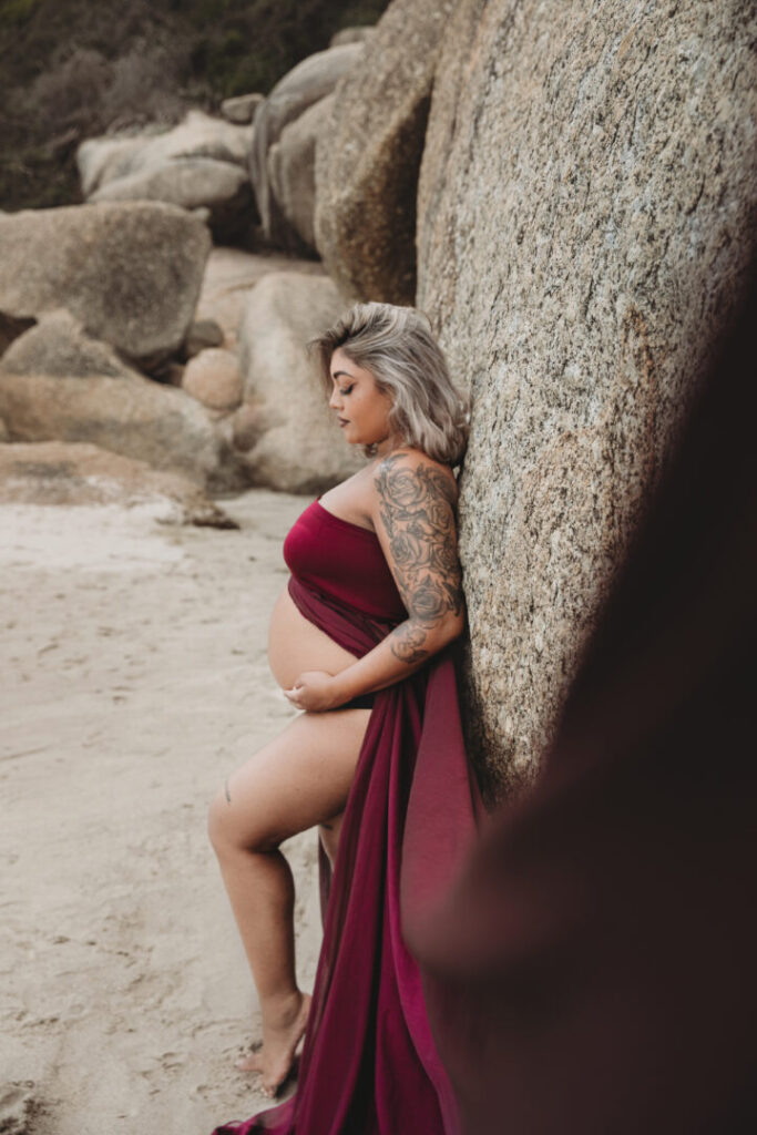 Cape Town maternity photographer photographing a pregnant woman in a flowing purple dress at Llandudno Beach