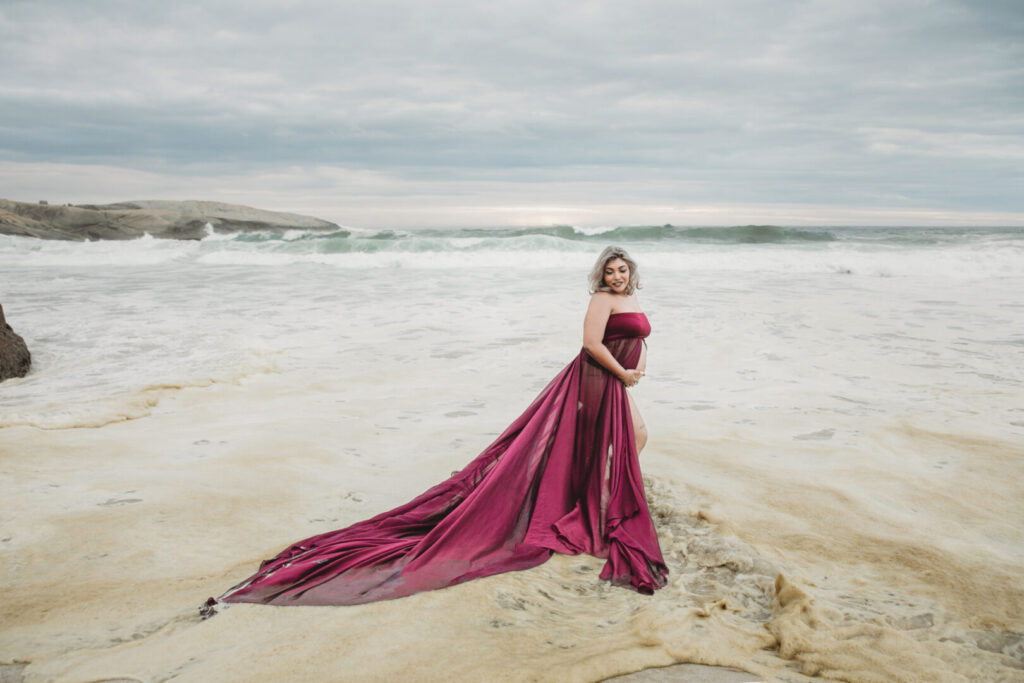 Cape Town maternity photographer photographing a pregnant woman in a flowing purple dress at Llandudno Beach