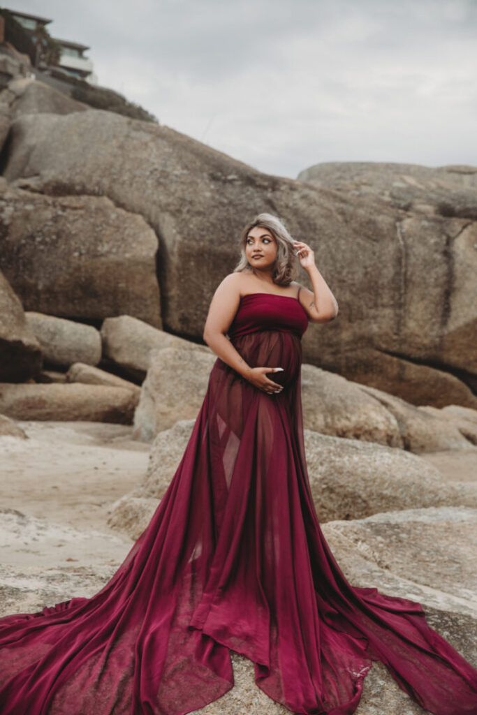 Maternity photography session in Cape Town with a pregnant mom wearing a purple dress on Llandudno Beach