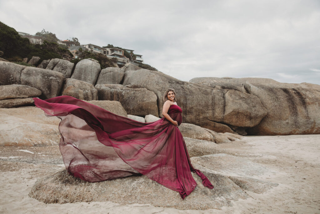 Maternity photography session in Cape Town with a pregnant mom wearing a purple dress on Llandudno Beach