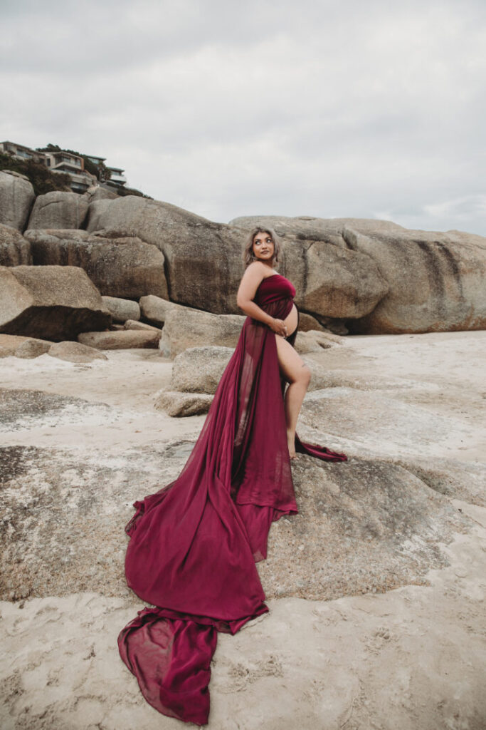 Llandudno Beach maternity photoshoot in Cape Town featuring an expectant mother in a purple dress