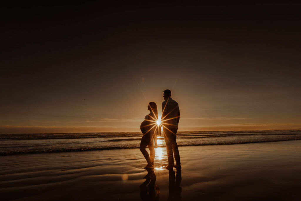 silhouette of pregnant mom and her partner at sunset in cape town