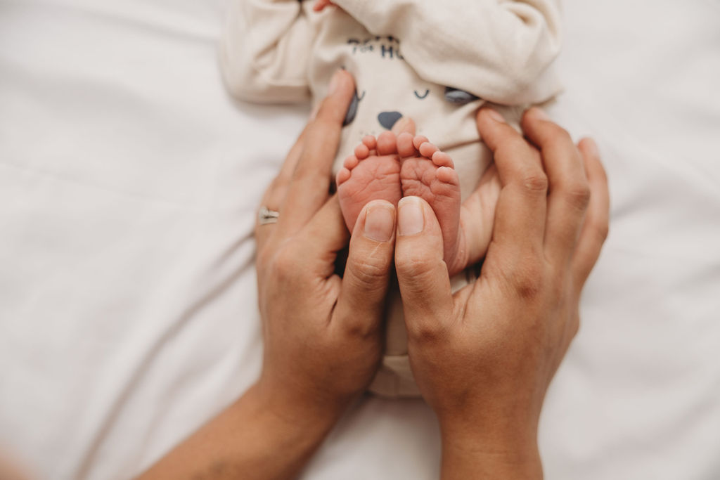 mom holding baby feet to show size different for a photo