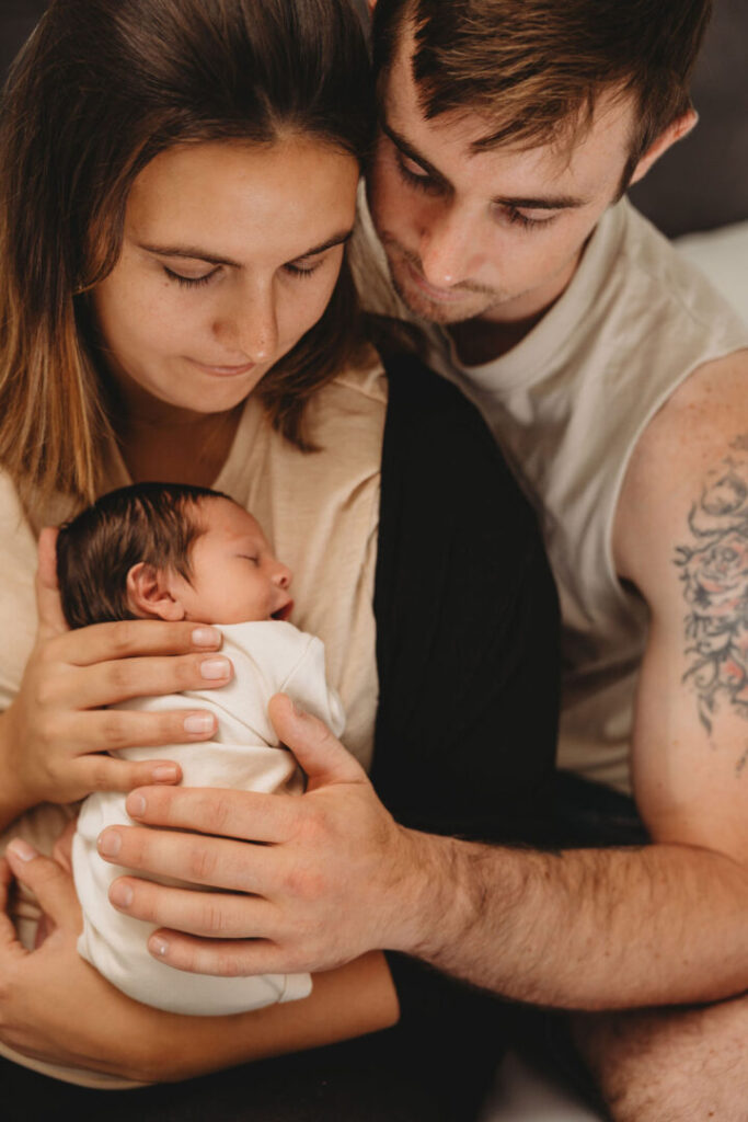 newborn baby with mom and dad at a photo shoot
